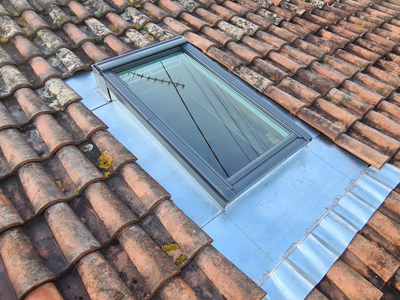 Toiture en tuiles avec fenêtre de toit Velux et habillage zinc posés par l'artisan couvreur CZB 33 en Gironde